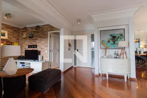 Ampla sala de estar com piso de madeira em apartamento de pós-leilão em São Paulo.